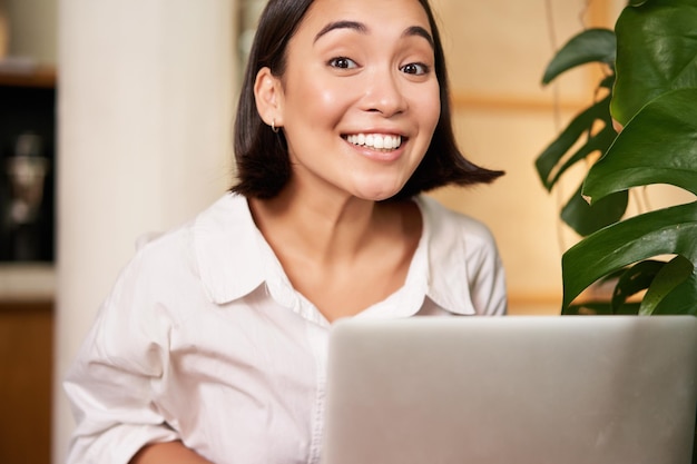 Mulher jovem usando laptop em casa