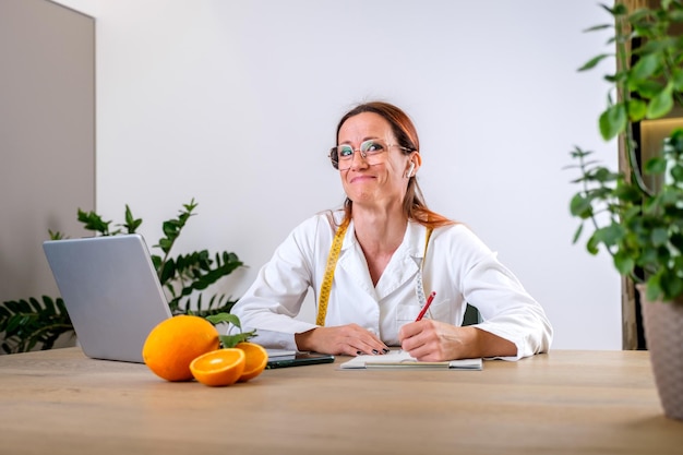 Mulher jovem usando laptop enquanto está sentada na mesa