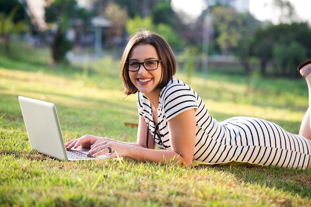 Mulher jovem usando laptop no parque