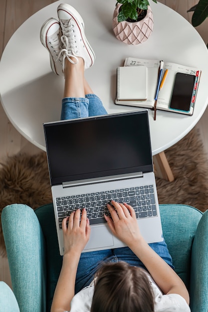 Mulher jovem usando laptop para trabalhar em casa, trabalho remoto