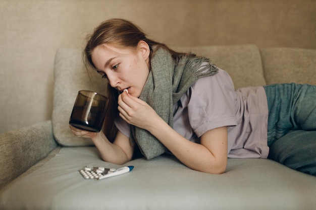 Foto mulher jovem usando lenço tem gripe doente doença frio em casa dentro de casa