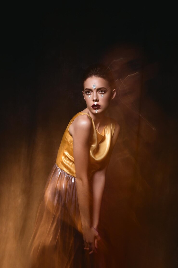 Foto mulher jovem usando maquiagem e vestido contra fundo preto