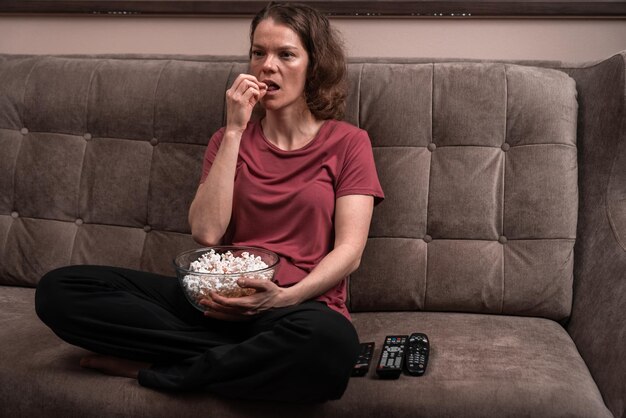 Foto mulher jovem usando o telefone enquanto está sentada no sofá