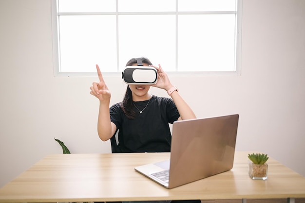 Mulher jovem usando óculos de Realidade Virtual na sala de escritório Educação on-line estudando videogame
