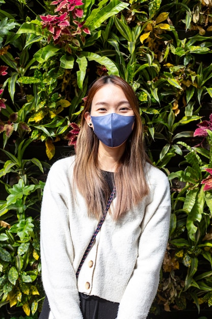 Foto mulher jovem usando óculos de sol contra plantas