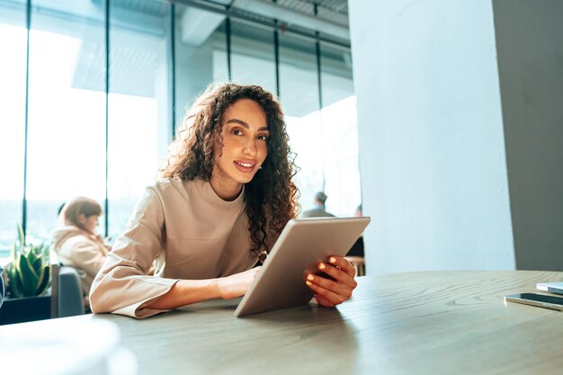 Mulher jovem usando tablet digital em um café