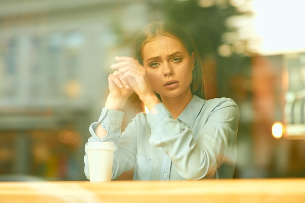 Mulher jovem usando telefone celular em um café