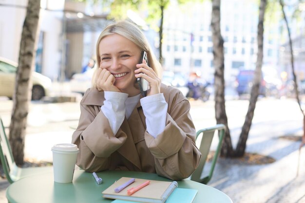 Mulher jovem usando telefone celular em um café