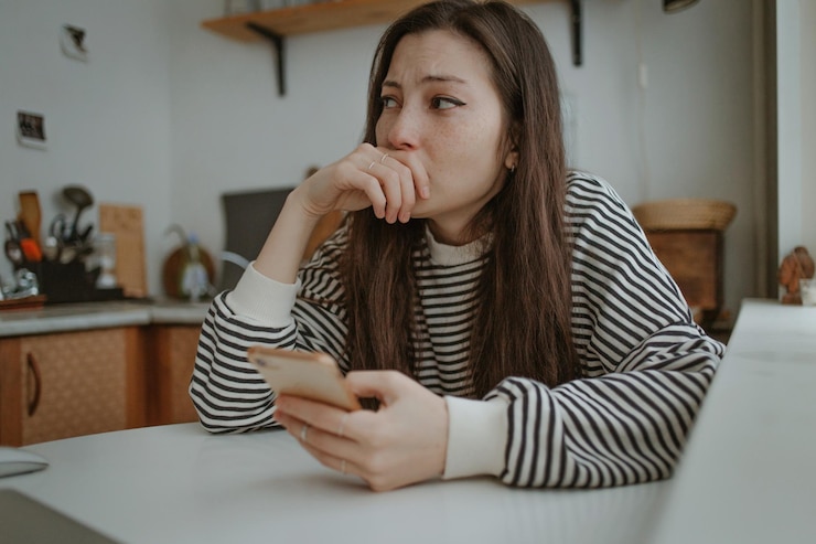 Foto mulher jovem usando telefone celular enquanto está sentada em casa