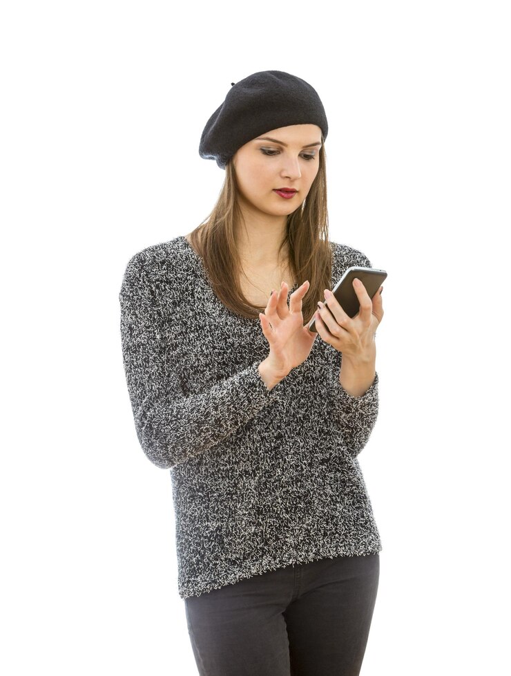 Foto mulher jovem usando telefone enquanto está de pé contra um fundo branco