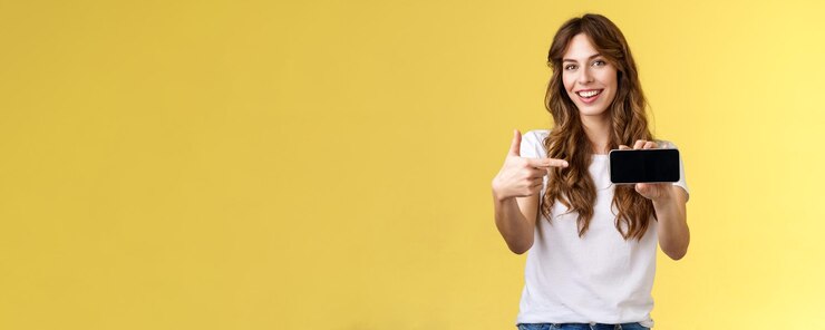 Foto mulher jovem usando telefone móvel contra fundo amarelo