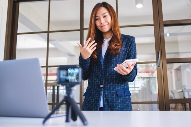 Foto mulher jovem usando telefone móvel enquanto está de pé na mesa