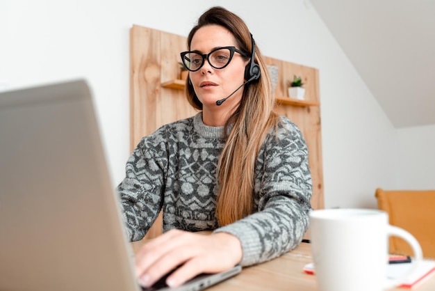 Mulher jovem usando telefone móvel enquanto está sentada na mesa