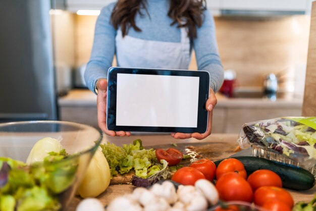 Mulher jovem, usando, um, tabuleta, computador, cozinhar, em, dela, cozinha