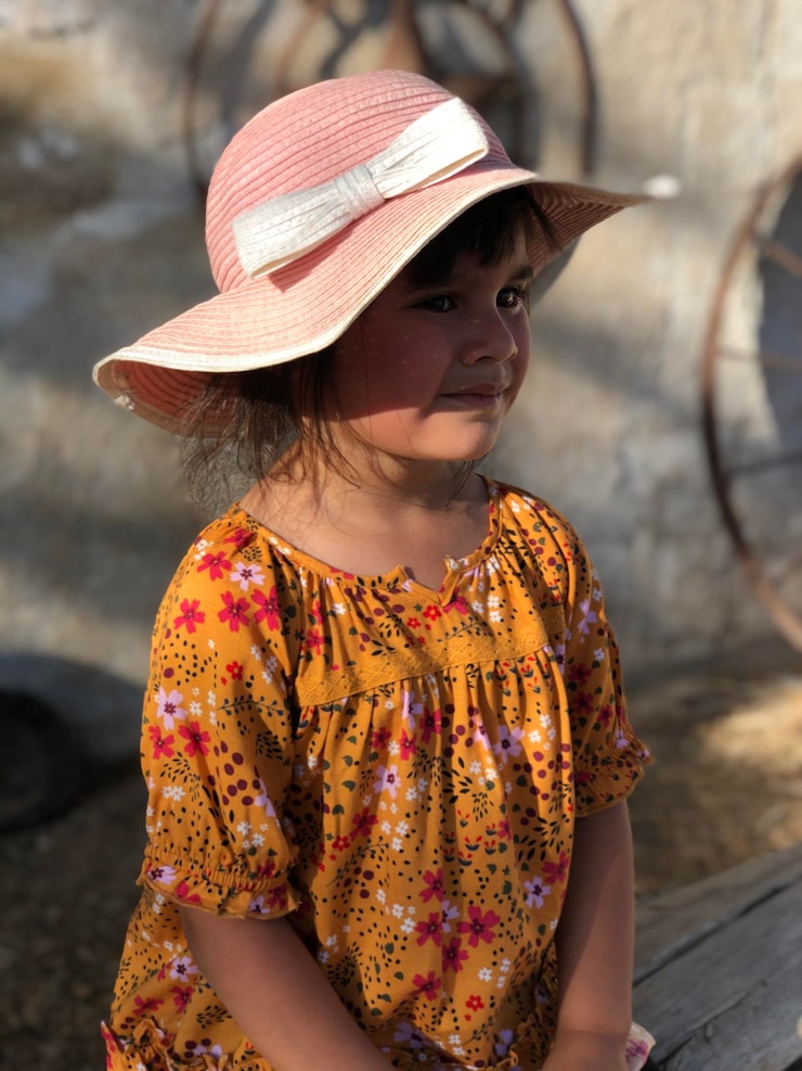 Foto mulher jovem vestindo chapéu de pé ao ar livre