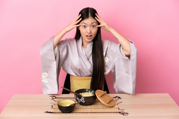 Mulher jovem vestindo quimono e comendo macarrão