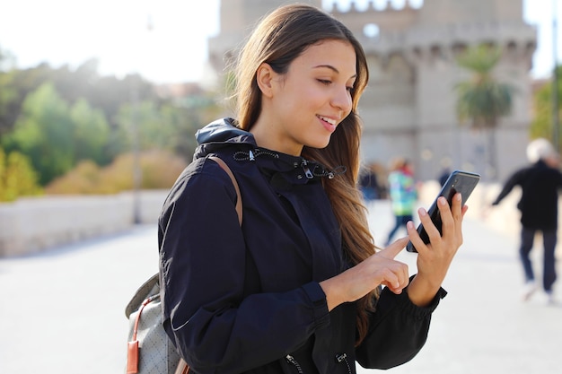 Mulher jovem viajante usando mapa de aplicativo no smartphone