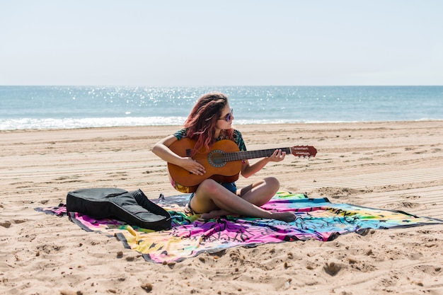 Mulher jovem, violão jogo, praia