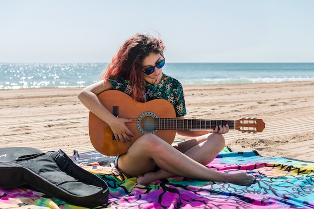 Mulher jovem, violão jogo, praia