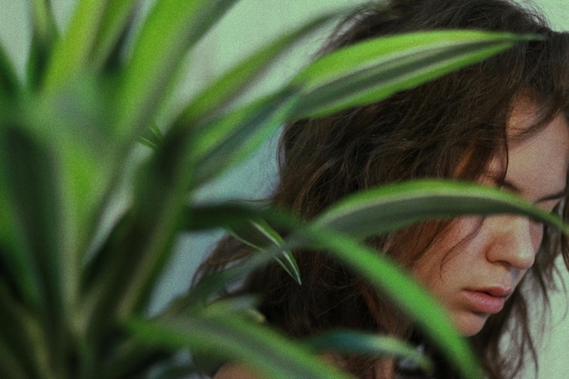 Mulher jovem vista através de plantas