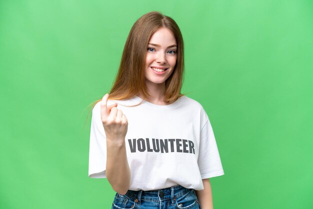 Mulher jovem voluntária sobre fundo chave de croma isolado fazendo gesto de vinda