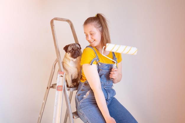 mulher juntamente com um cão pug fazem reparos no apartamento