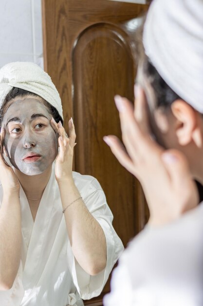 mulher latina aplicando uma máscara facial após o banho para um tratamento de cuidados com a pele