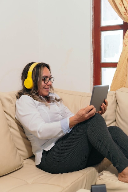 Mulher latina com fones de ouvido assistindo a um filme em um tablet