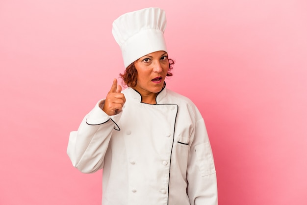 Mulher latina de meia-idade isolada no fundo rosa, tendo uma ideia, o conceito de inspiração.