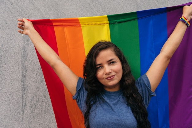 Mulher latina em pé na rua com a bandeira lgtb. conceito lgbt