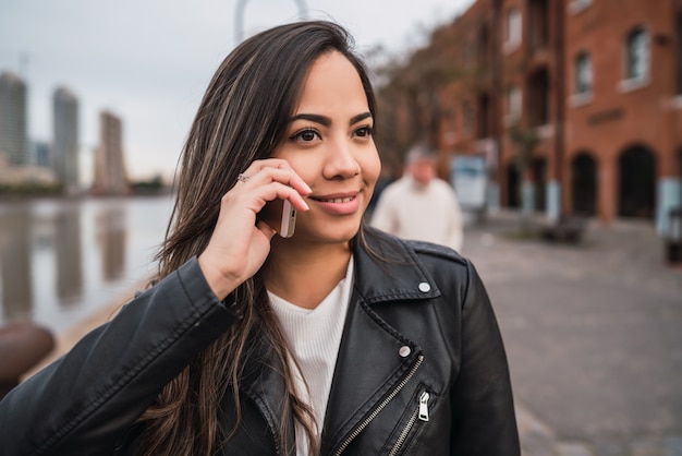 Mulher latina falando ao telefone.