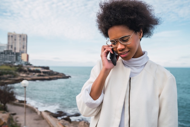 Mulher latina falando ao telefone.