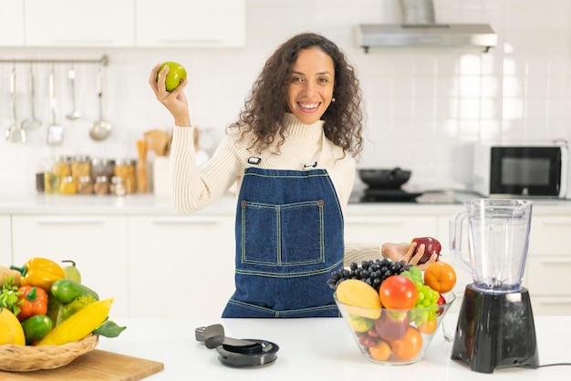 Mulher latina fazendo suco na cozinha - para vegetariano