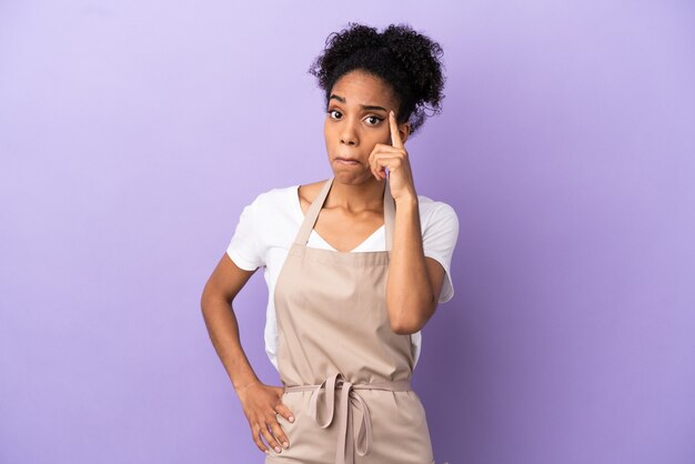 Mulher latina garçom de restaurante isolada em fundo roxo pensando uma ideia