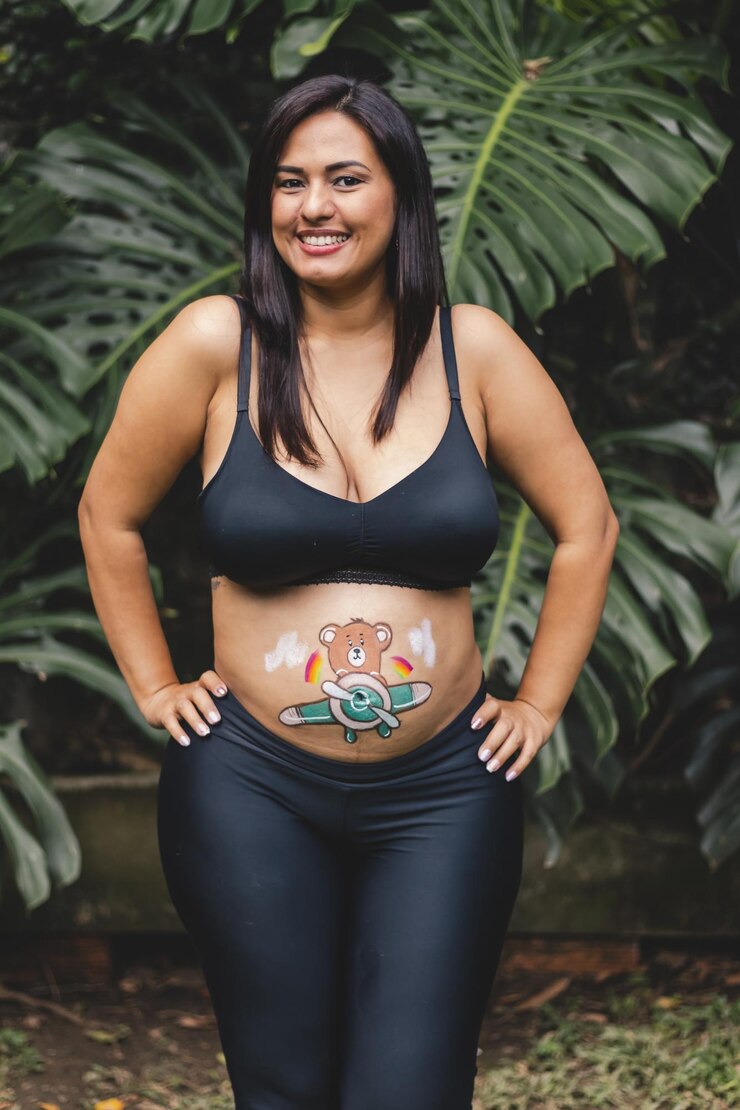 Foto mulher latina grávida sorrindo com desenho na barriga