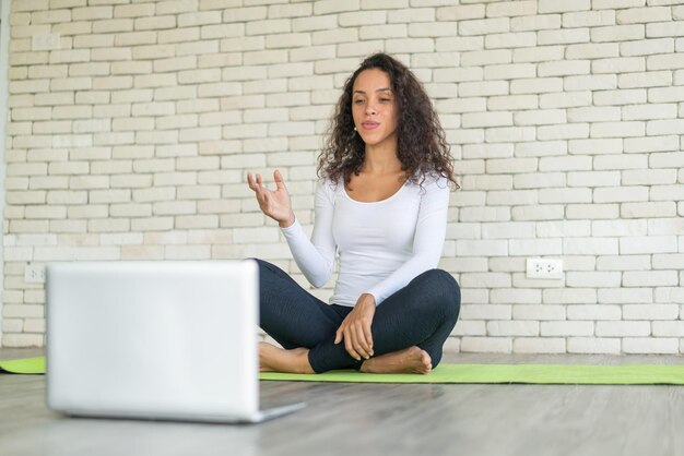 Mulher latina influenciadora ensinando ioga online