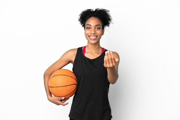 Mulher latina jovem jogador de basquete isolada no fundo branco, convidando para vir com a mão. Feliz que você veio