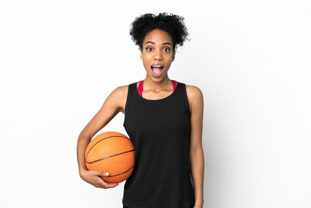 Mulher latina jovem jogadora de basquete isolada no fundo branco com expressão facial surpresa