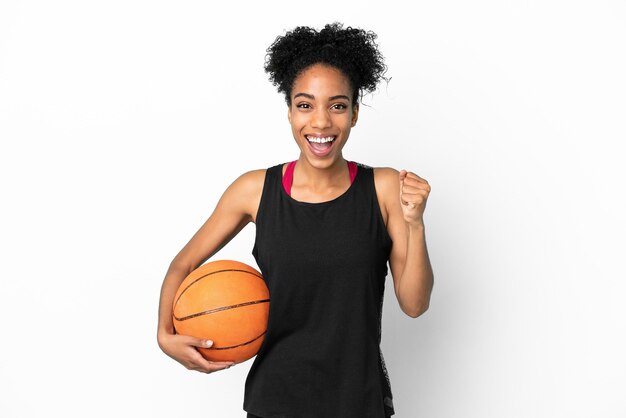 Mulher latina jovem jogadora de basquete isolada no fundo branco comemorando vitória na posição de vencedora