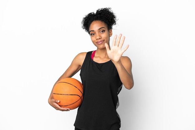 Mulher latina jovem jogadora de basquete isolada no fundo branco contando cinco com os dedos