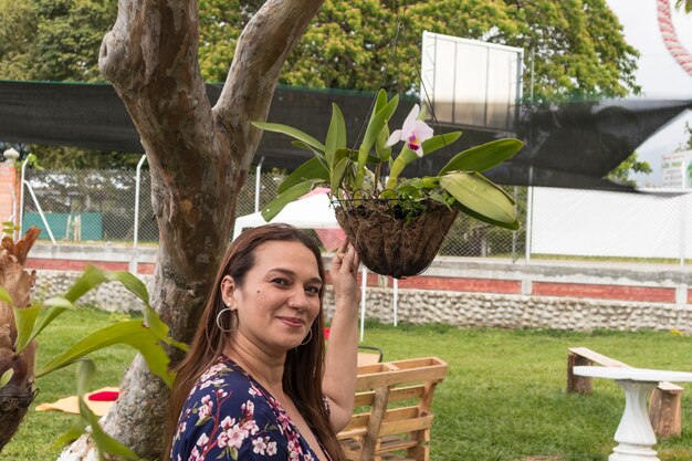 mulher latina mostrando uma flor de orquídea colombiana Orchidaceae