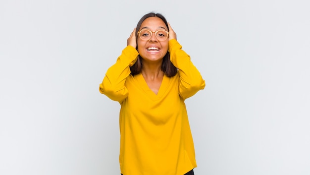 Mulher latina parecendo feliz, despreocupada, amigável e relaxada curtindo a vida e o sucesso, com uma atitude positiva