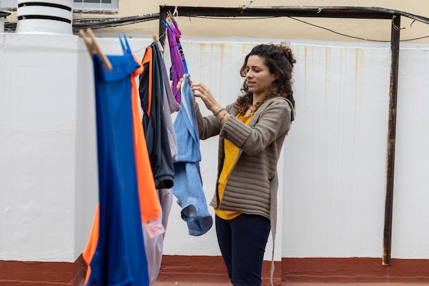 Mulher latina pendurando roupas no varal