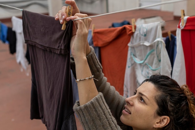 Mulher latina pendurando roupas no varal