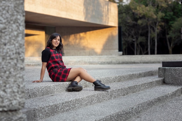 Mulher latina sentada nas escadas de um museu na Cidade do México com espaço para cópia