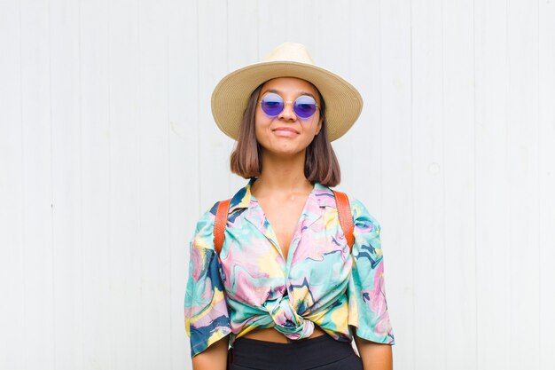 Mulher latina sorrindo positivamente e com confiança, parecendo satisfeita, amigável e feliz