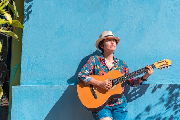 Mulher latina tocando guitarra ao ar livre