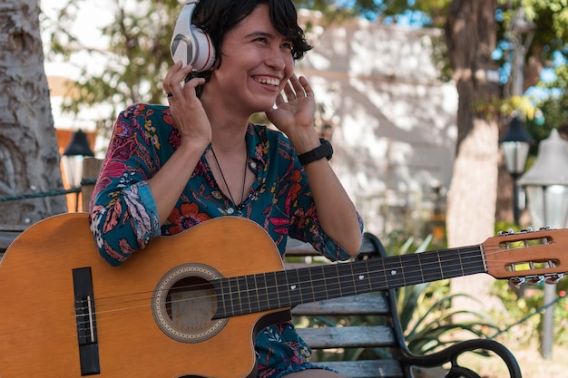 Mulher latina tocando violão no parque