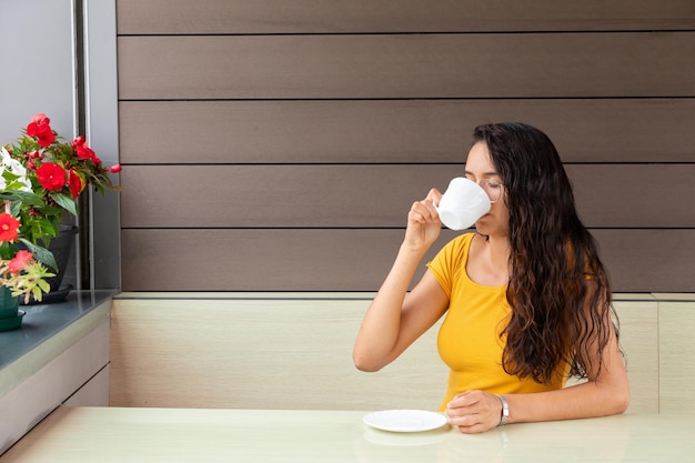 Foto mulher latina tomando café no café