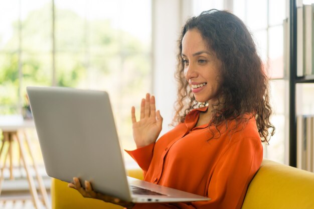 mulher latina trabalhando com laptop no sofá em casa